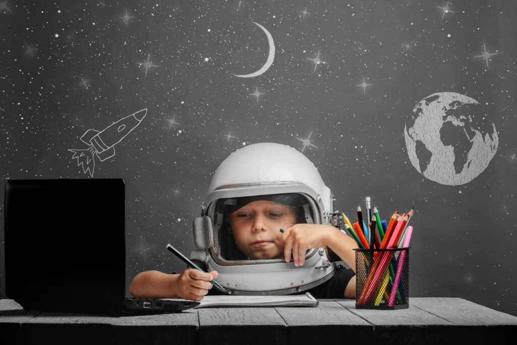 Child dressed as Astronaut while drawing